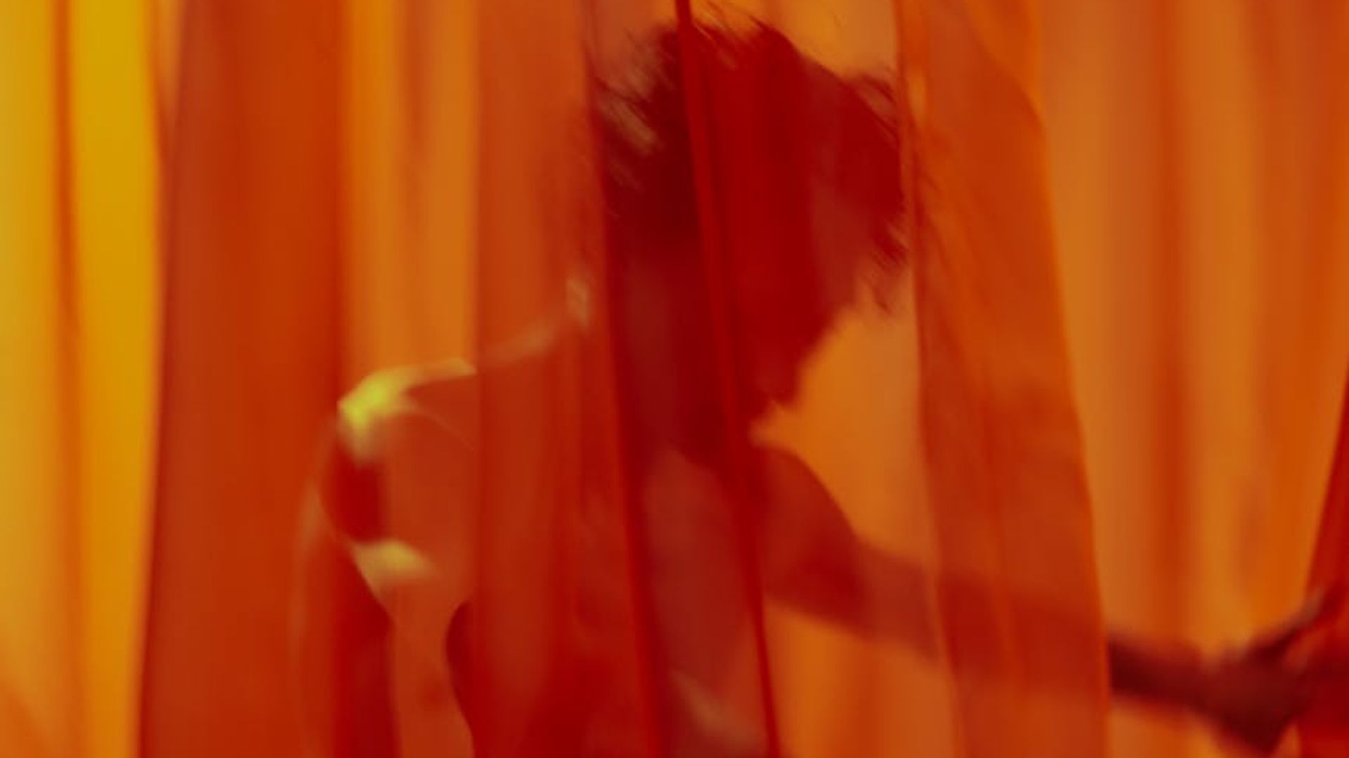 Serene person performing a fluid movement in a minimalist space.